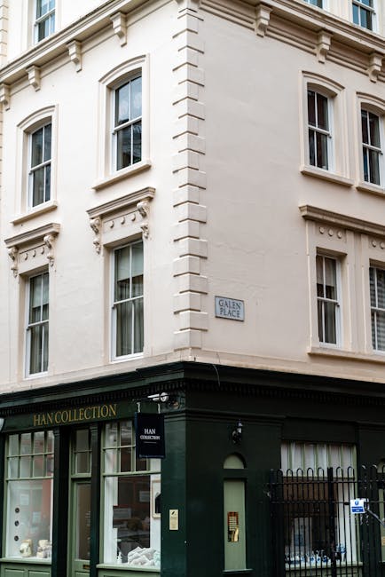 Image of a quiet street corner in Marylebone with red brick residential buildings featuring numerous white-framed windows, and a small commercial storefront with blue accents and signage for art frami